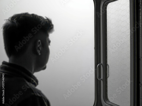 Obraz na płótnie A man is looking out a window. The window is dirty and has a spider web on it. The man is looking out the window with a serious expression on his face w salonie