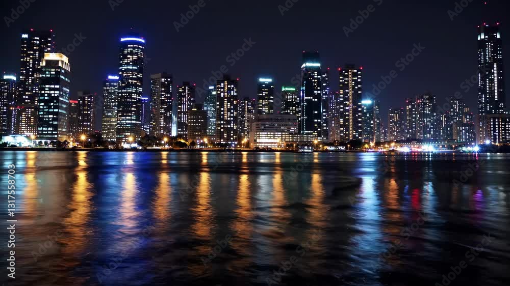Vibrant city skyline illuminated at night along the waterfront Vibrant city skyline illuminated at night along the waterfront