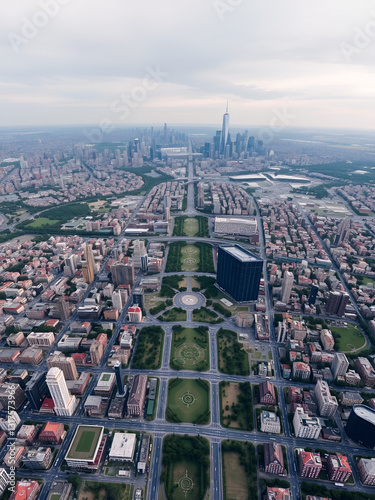A bird-eye view of a sprawling urban sprawl, with grids of roads, parks, and skyscrapers stretching to the horizon