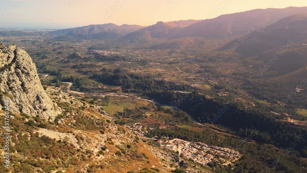 Golden sunlight bathes a picturesque valley nestled amidst rolling hills, showcasing a serene landscape with scattered houses and lush greenery Golden sunlight bathes a picturesque valley nestled amidst rolling hills, showcasing a serene landscape with scattered houses and lush greenery