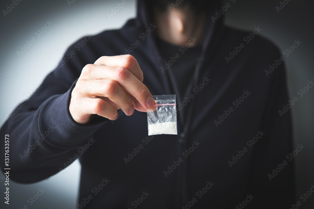 man in sweatshirt and hoodie faceless holds small bag with white substance - drug, concept of drug addiction, dependence and distribution