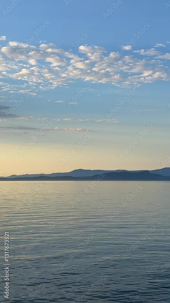 background for advertising travel to the sea or ocean only sky and water horizon light blue ocean and yellow sunset nature mountains are visible in the distance empty frame for text. High quality 4k background for advertising travel to the sea or ocean only sky and water horizon light blue ocean and yellow sunset nature mountains are visible in the distance empty frame for text. High quality 4k
