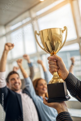 Close-up of hands holding a golden trophy cup. A team of employees celebrating their achievement and teamwork.