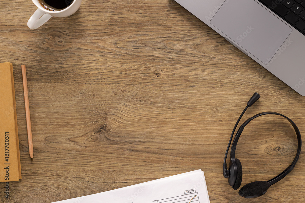 Top view of a wooden office desk with a laptop, coffee, headset, documents, and a notebook. A modern workspace setup for remote work, customer support, or online communication