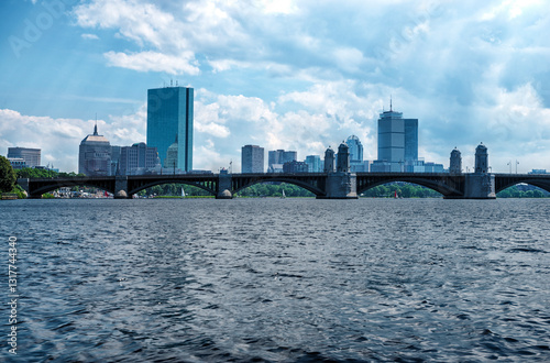 Obraz na płótnie The iconic Boston skyline with the Longfellow Bridge spanning the Charles River, showcasing historic architecture, modern skyscrapers, and a serene waterfront under a partly cloudy sky. w salonie