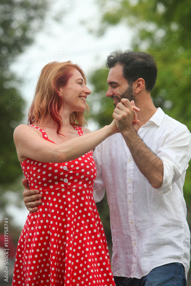 cheerful young man and woman dancing in park on summer day cheerful young man and woman dancing in park on summer day