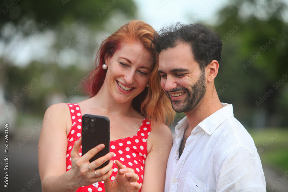 portrait of cheerful young couple in love using smartphone outdoors smiling portrait of cheerful young couple in love using smartphone outdoors smiling