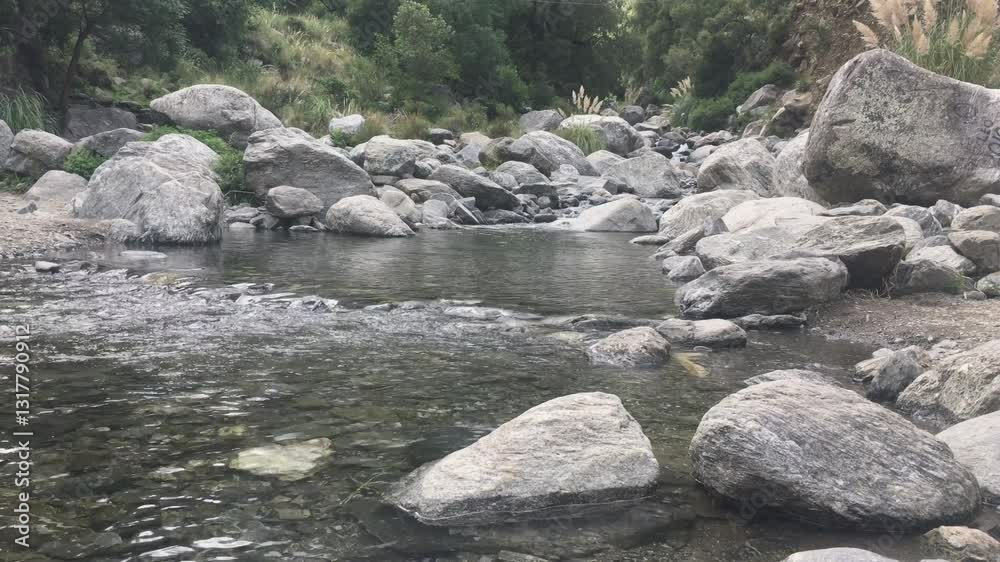 Crystal-clear stream flowing through rocky landscape Crystal-clear stream flowing through rocky landscape