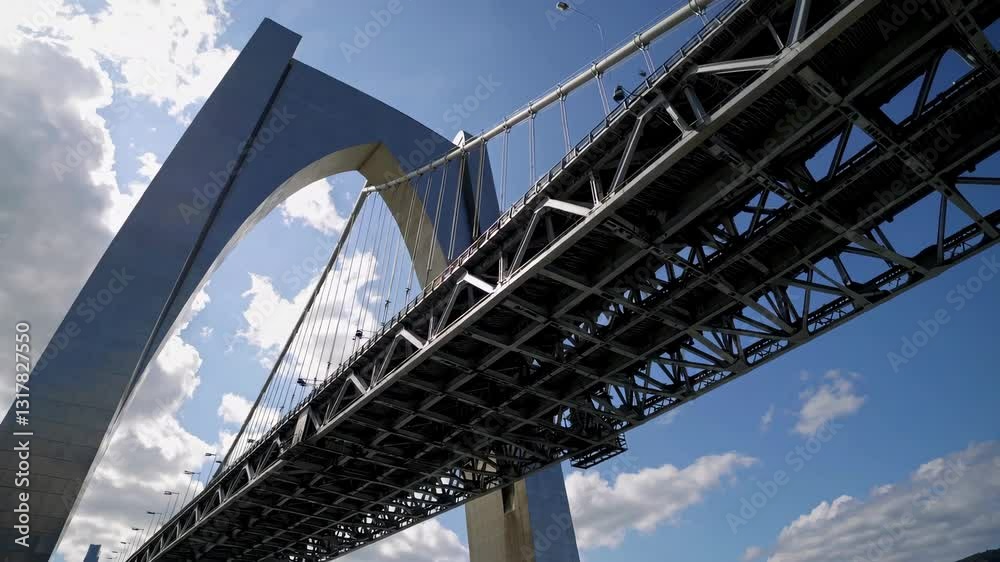 Captivating view of the modern bridge under a bright blue sky with fluffy clouds Captivating view of the modern bridge under a bright blue sky with fluffy clouds