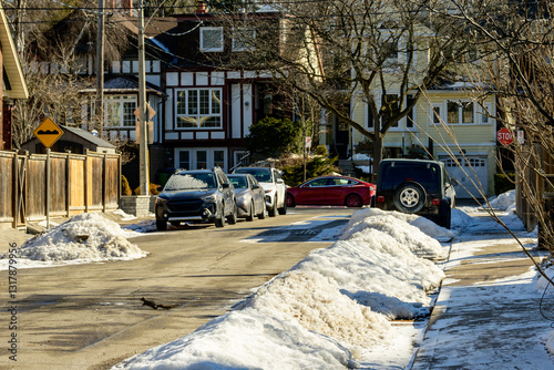 Photography Snow banks blocking parking spaces on a residential street in Toronto slowly mel