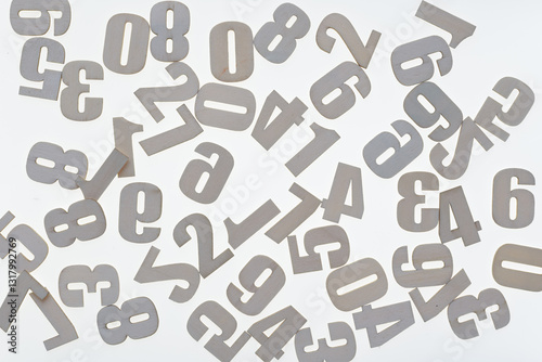 scattered, plain unpainted wood numbers arranged on a bright surface