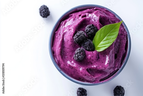 Delicious vibrant purple berry sorbet with fresh blackberries and green leaf garnish served in a bowl