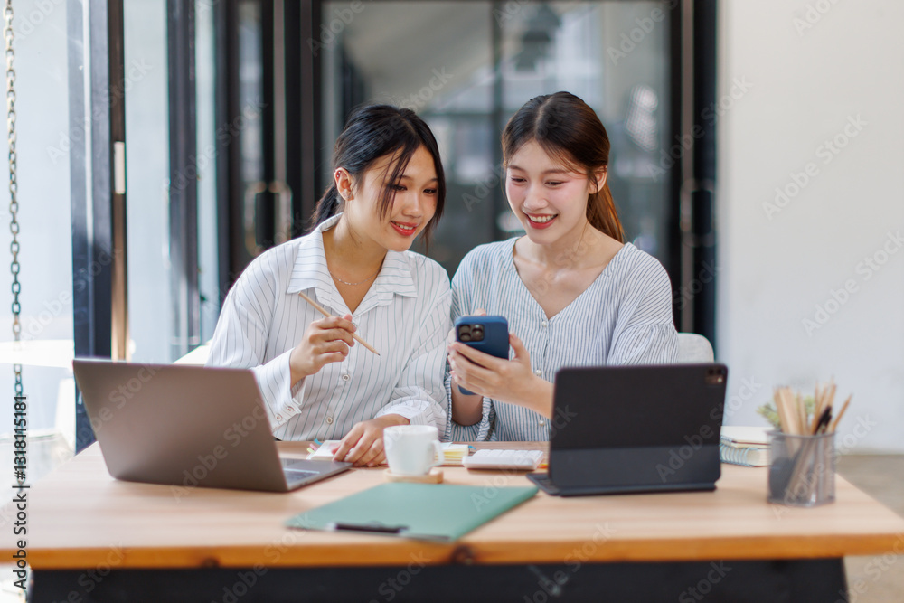Two happy business asian women coworking with a laptop in a desktop at office
Two happy business asian women coworking with a laptop in a desktop at office
