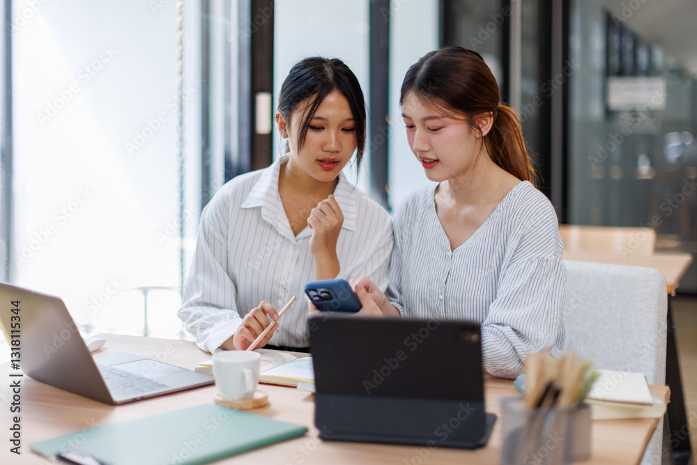 Two happy business asian women coworking with a laptop in a desktop at office
Two happy business asian women coworking with a laptop in a desktop at office