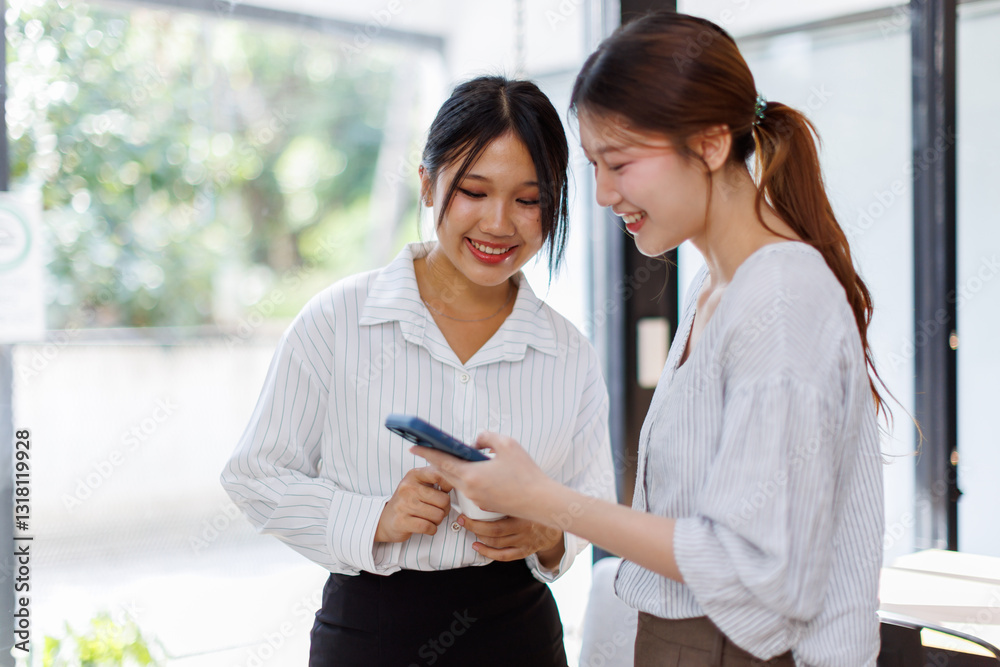 Two Cheerful asian Business women standing in the workplace office and discussing their ideas
Two Cheerful asian Business women standing in the workplace office and discussing their ideas