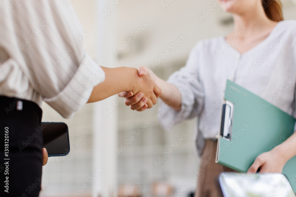 Obraz premium Cheerful asian businesswomen shaking hands in meeting room 