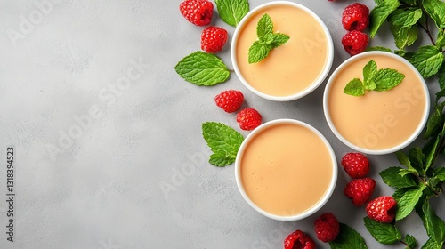 Creamy Dessert with Fresh Raspberries and Mint Leaves on Gray Background photo