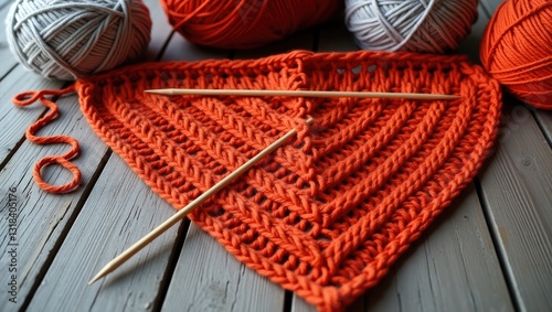 Close-up of red yarn and knitting needles.