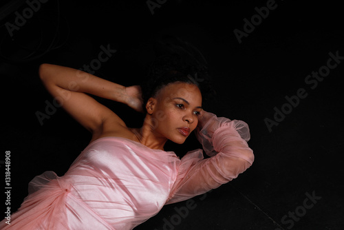 Wallpaper Mural Beautiful curly woman in pink dress lying on black floor Torontodigital.ca