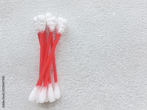 A pile of cotton swabs lies on a gray table, there is a place for text on the side, top view. Hygienic cotton swabs for ears.  photo