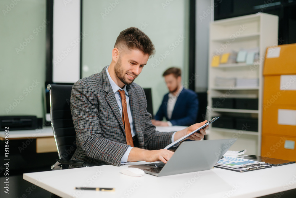 Confident businessman working on finance analysis with a tablet and laptop at office desk Confident businessman working on finance analysis with a tablet and laptop at office desk