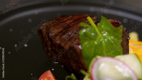 Chef serves beef steak. Slow motion.