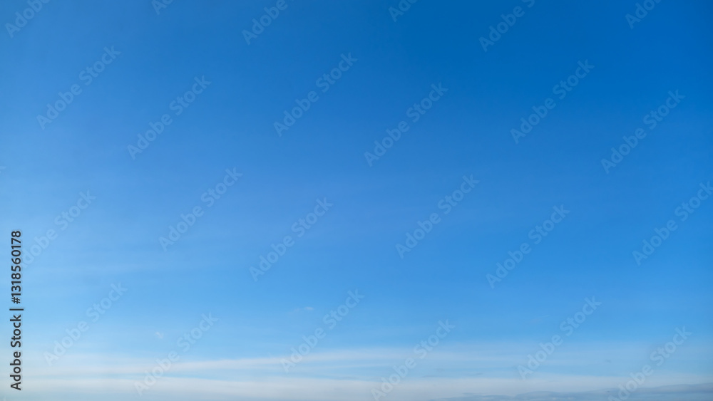 Obraz premium Clear blue sky with light clouds on the horizon, copy space. Natural background with copy space for design and print.