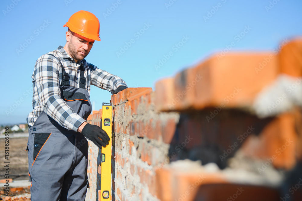 Installing brick wall. Construction worker in uniform and safety equipment have job on building Installing brick wall. Construction worker in uniform and safety equipment have job on building
