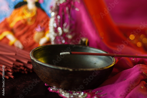 An incense stick smolders in a trickle of smoke photo