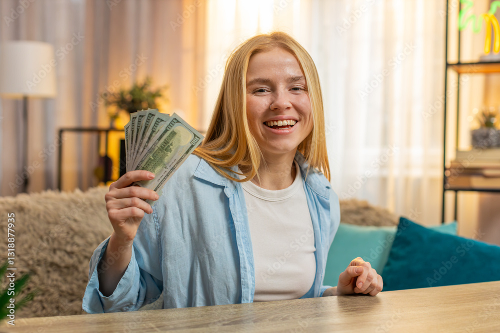Young woman sits at home counting money dollar cash in hand, happy laughter from sudden lottery jackpot victory, salary, earnings. Caucasian girl waves banknotes celebrating financial surprise. Sunset Young woman sits at home counting money dollar cash in hand, happy laughter from sudden lottery jackpot victory, salary, earnings. Caucasian girl waves banknotes celebrating financial surprise. Sunset