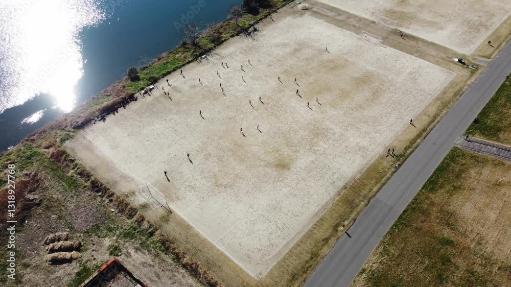 Children’s Soccer Match on a Riverbank – 4K Aerial View Children’s Soccer Match on a Riverbank – 4K Aerial View