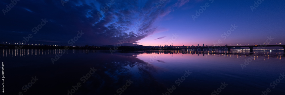 Fototapeta premium A breathtaking panorama that exquisitely captures the enchanting twilight hues reflecting over a tranquil river, beautifully showcasing a serene skyline that evokes peace and calmness in nature