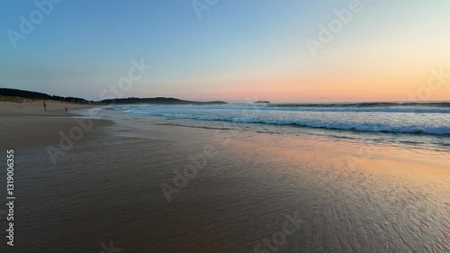 Wallpaper Mural A peaceful and tranquil beach scene at sunset, showcasing gentle waves along with soft colors spreading in the sky Torontodigital.ca