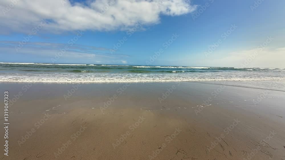 A serene and peaceful beach view showcasing gentle, soothing waves under a perfectly clear blue sky A serene and peaceful beach view showcasing gentle, soothing waves under a perfectly clear blue sky