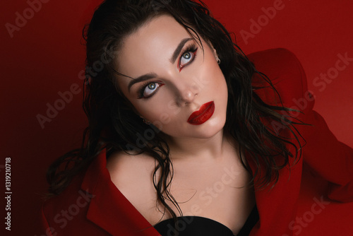Young Woman In Red Suit With Red Lips Posing On The Red Background