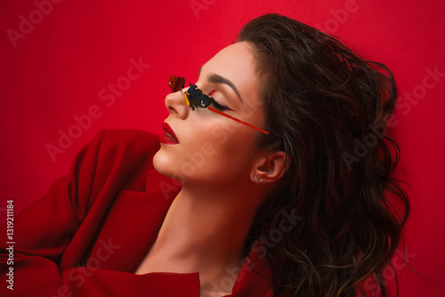 Young Woman In Red Suit With Red Lips And Sunglasses Posing On The Red Background