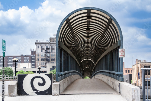 The 4th Street Bridge covered walkway in downtown Waterloo, Iowa on a beautiful summer day with clouds in the sky. photo