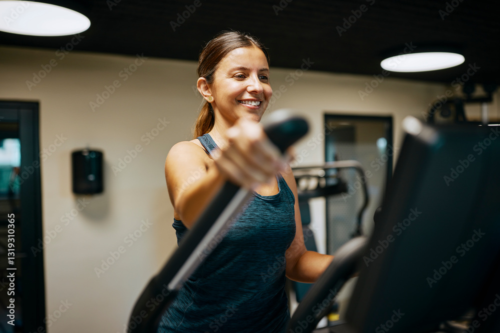 Smiling Woman Exercising on Elliptical Machine in Modern Fitness Gym Smiling Woman Exercising on Elliptical Machine in Modern Fitness Gym
