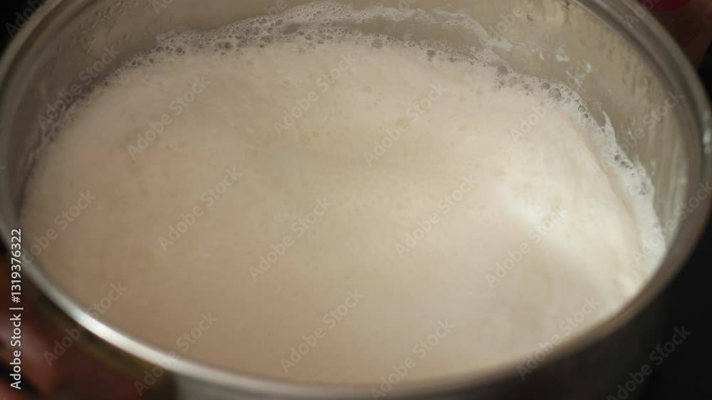 boiling milk in a saucepan on the stove close-up, boiling milk in the kitchen, cooking dairy dishes boiling milk in a saucepan on the stove close-up, boiling milk in the kitchen, cooking dairy dishes