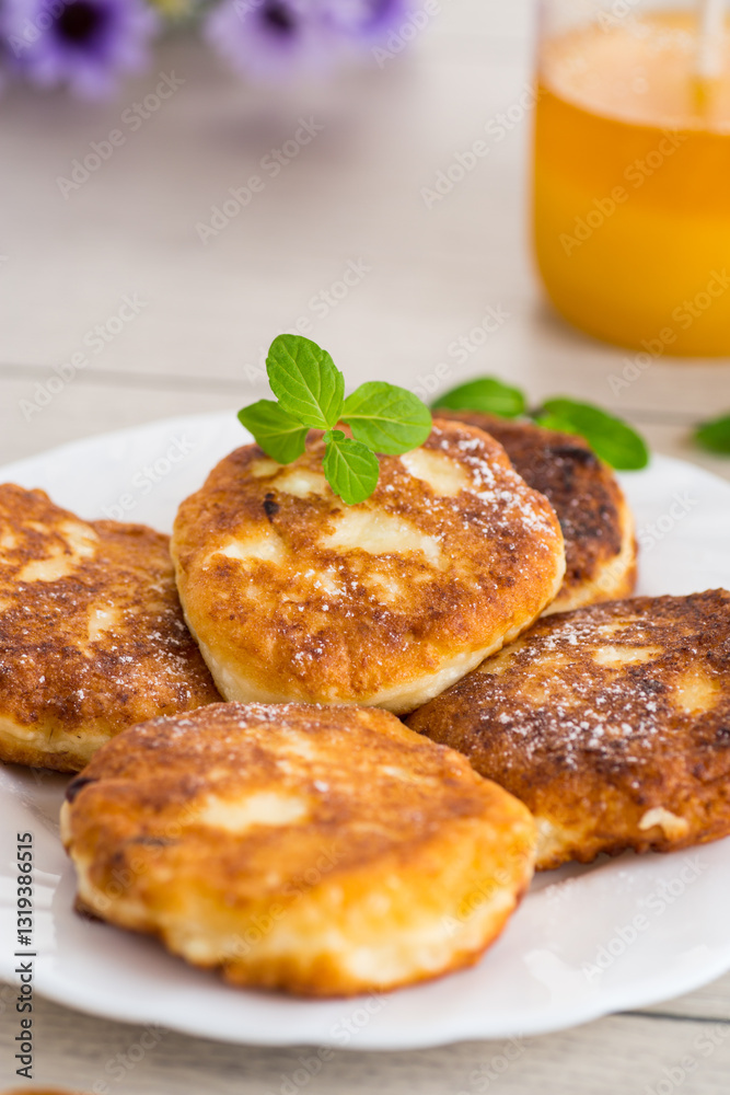 Appetizing cheese pancakes with a golden crust and a drop of honey Appetizing cheese pancakes with a golden crust and a drop of honey