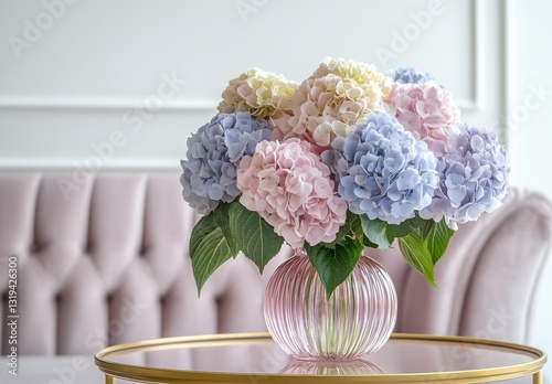 Elegant pastel hydrangea bouquet arrangement in a stylish glass vase on a gold coffee table in a modern interior setting
