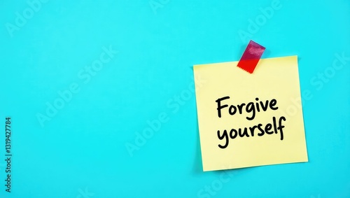 Stick note on a blue background with handwritten text, conveying the idea of learning to fully accept your actions â€“ release any resentment from significant mistakes you have made. photo