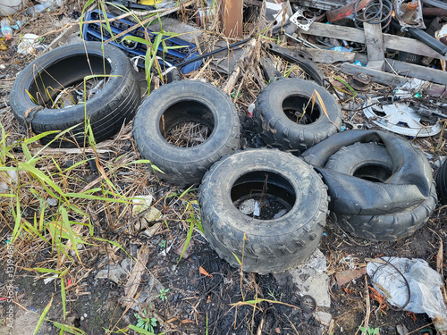 There is a landfill on the ground with old tires and tires for recycling. Disposal of used tires