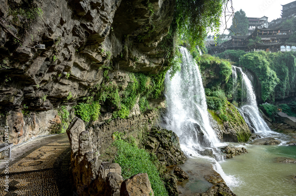 Obraz premium Beautiful waterfall and ancient village at Furongzhen or Furong ancient town in Hunan, China.