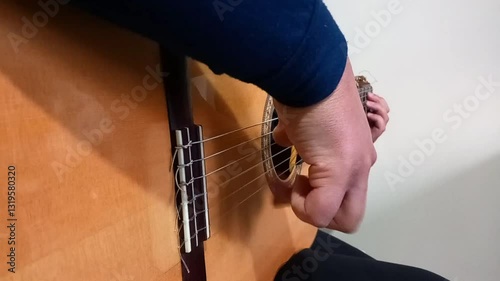 A closeup shot of the guitarist right hand from right angle side that play tremolo and chanage guitar chords easily