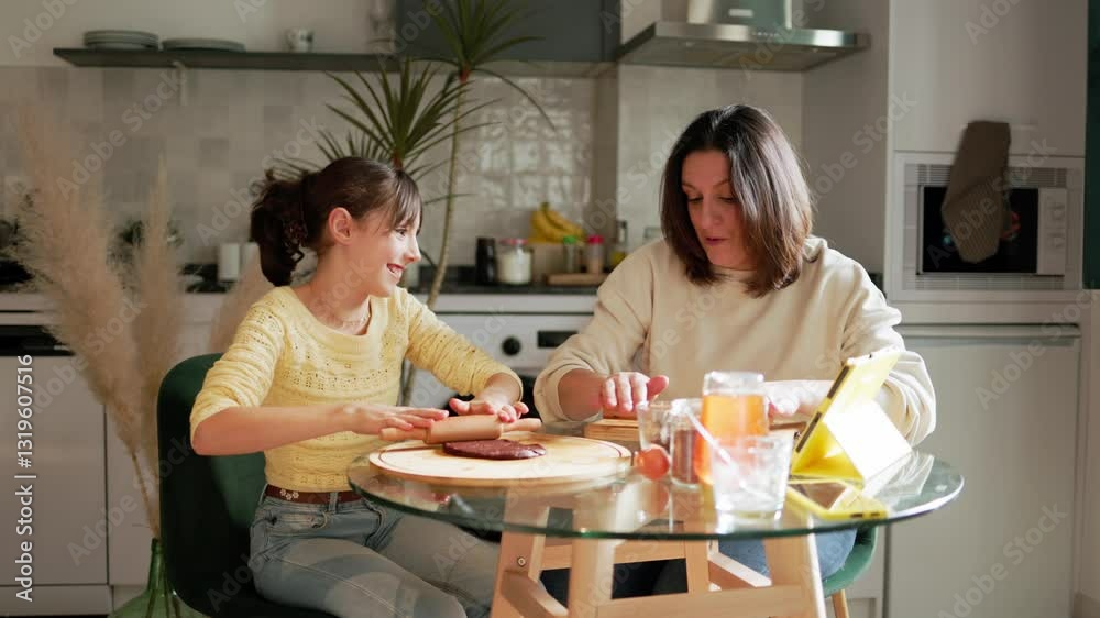 Mother and daughter baking cookies together in modern kitchen Mother and daughter baking cookies together in modern kitchen