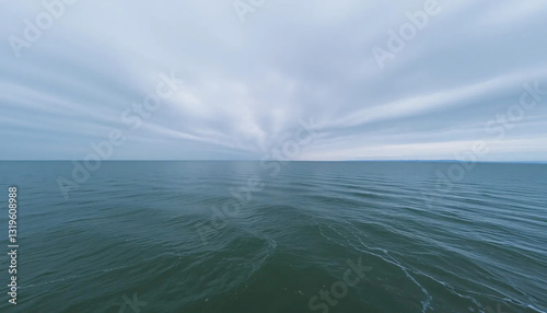 Serene Panoramic View of Tranquil Sea Under Dramatic Converging Clouds
