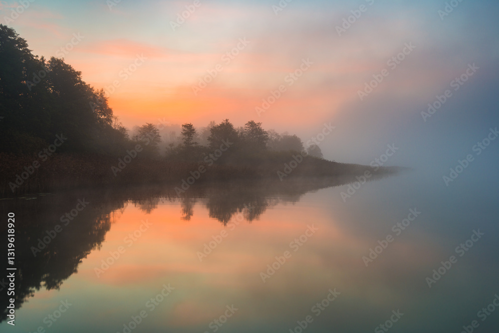 Sunrise over a tranquil lake in Sweden with fog and reflections Sunrise over a tranquil lake in Sweden with fog and reflections
