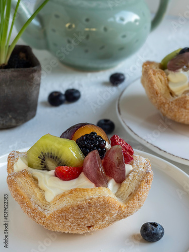Dolce cestino di pasta sfoglia con panna e frutta fresca sul tavolo della colazione