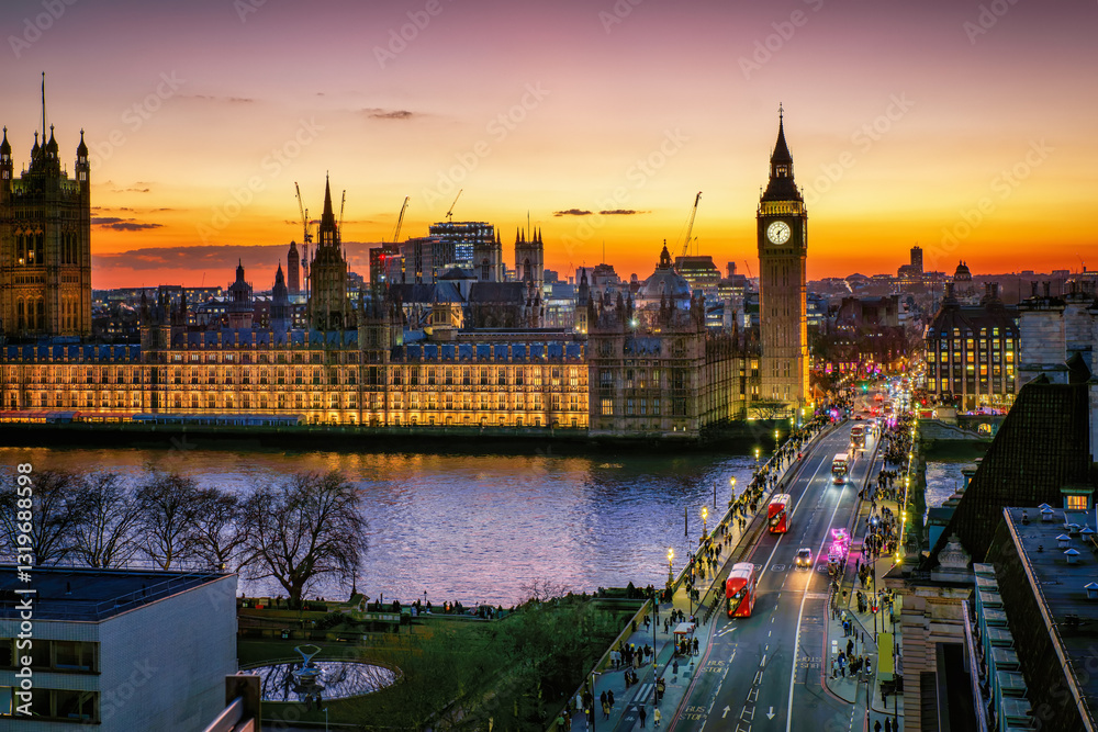 Elevated view of the illuminated Westminster Palace and Big Ben clock tower in London during dusk with street and people traffic, England